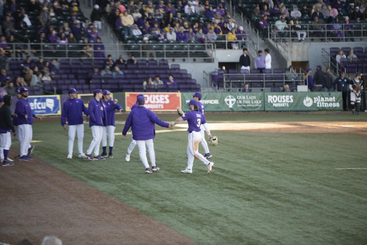 The infielders and catchers return to the dugout Saturday, Feb. 19, 2022, during the Tigers' 17-8 win against the University of Maine at Alex Box Stadium in Baton Rouge, La.