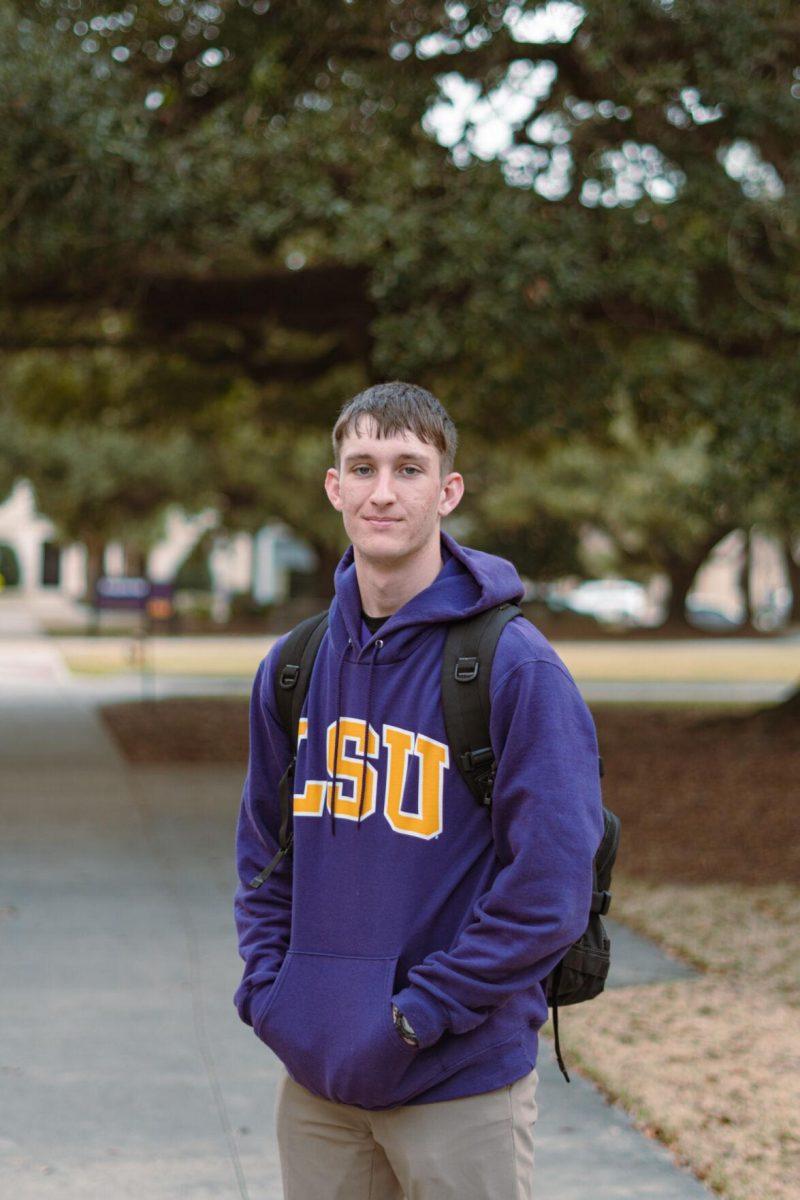 LSU freshman construction management major Russell Egnew places his hand in his purple LSU sweatshirt on Tuesday, Feb. 22, 2022, near Evangeline Hall on East Campus Drive in Baton Rouge, La.