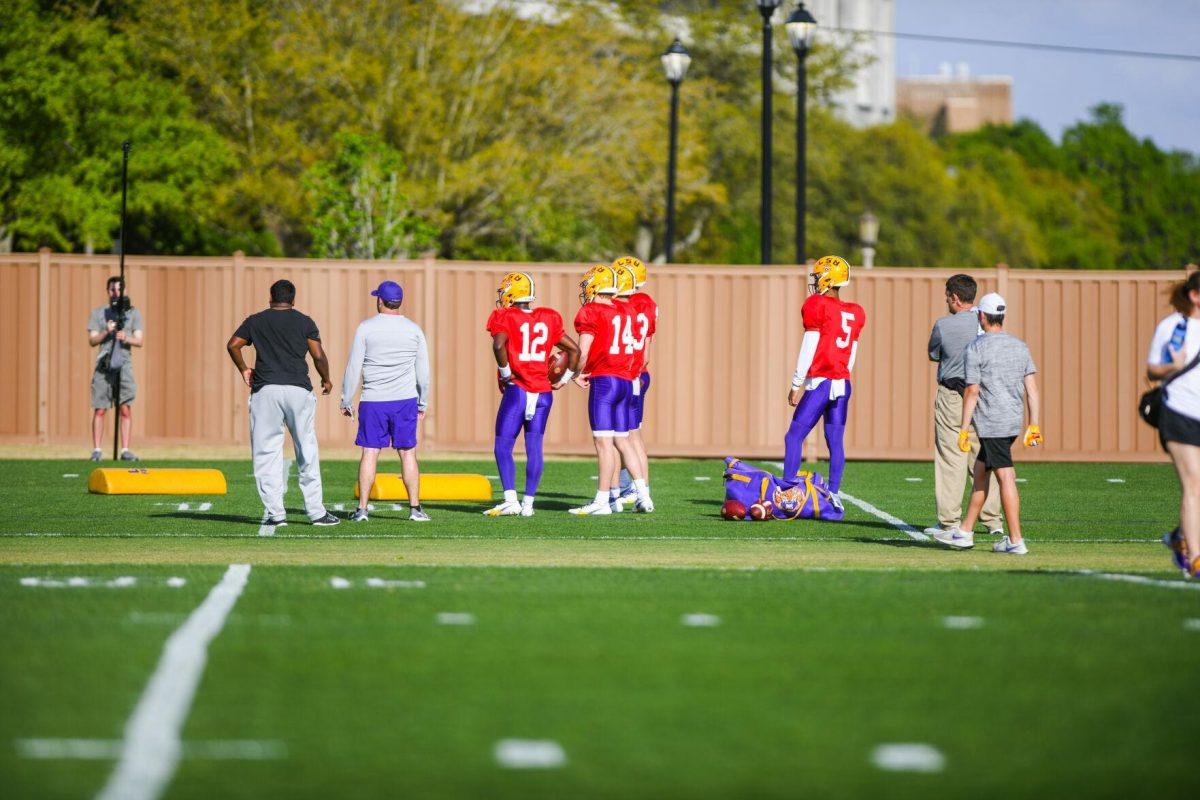 LSU football quarterbacks stand off to the side Tuesday, March 29, 2022 during LSU's spring practice in Baton Rouge, La.