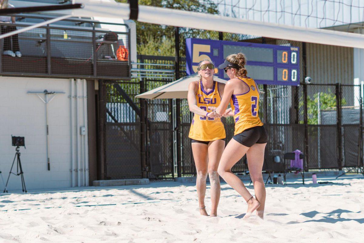 LSU beach volleyball redshirt junior Allison Coens (2) and junior Lara Boos (33) high five after a point on Sunday, March 27, 2022, during LSU&#8217;s 1-4 loss against TCU at the Beach Volleyball Stadium on Cypress Drive in Baton Rouge, La.