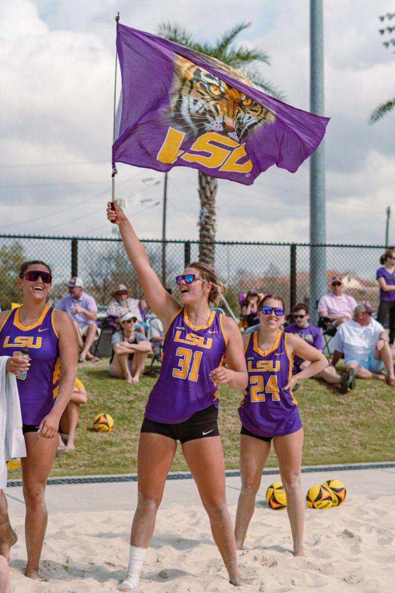 LSU beach volleyball redshirt freshman Brooke Blutreich (31) waves an LSU flag in support of her teammates on Sunday, March 6, 2022, during LSU&#8217;s 3-2 win over Loyola Marymount at the Beach Volleyball Stadium on Cypress Drive in Baton Rouge, La.