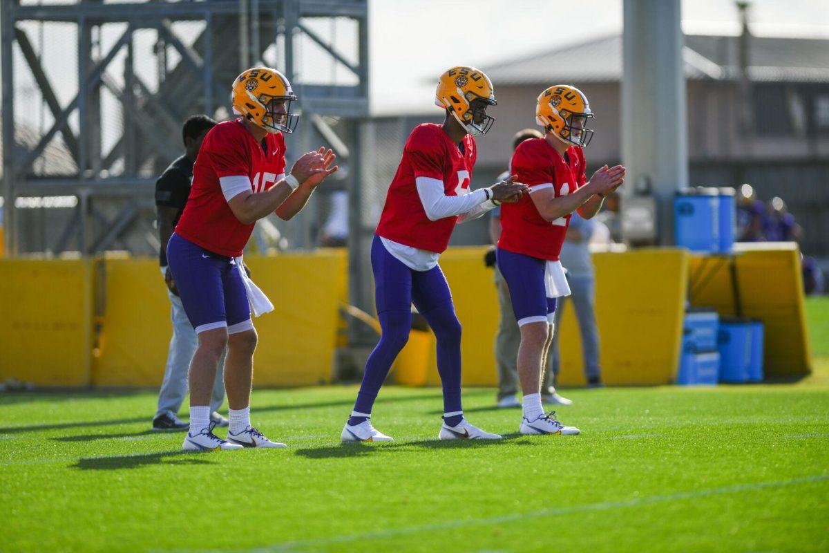 LSU football quarterbacks Myles Brennan (15), Jayden Daniels (5), and Walker Howard (14) wait to receive the ball Tuesday, March 29, 2022 during LSU's spring practice in Baton Rouge, La.