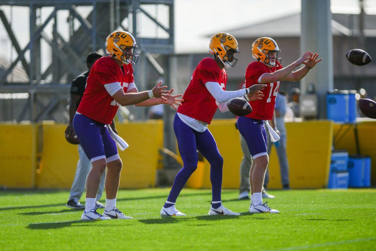 LSU football quarterbacks Myles Brennan (15), Jayden Daniels (5), and Walker Howard (14) wait to receive the ball Tuesday, March 29, 2022 during LSU's spring practice in Baton Rouge, La.