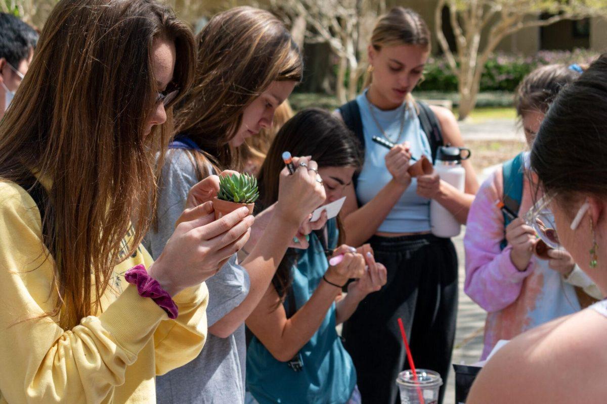 LSU students decorate their pots using stickers and paint pens.