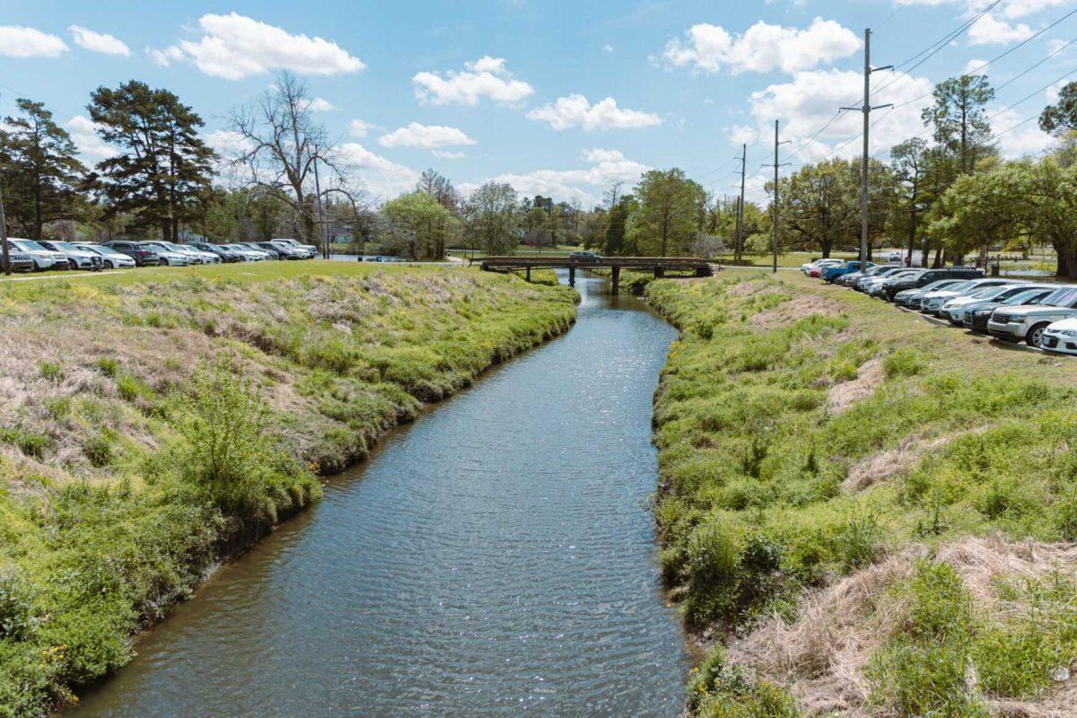 Water flows down a canal on Tuesday, March 29, 2022, near LSU&#8217;s Miller Hall on Campus Lake Road in Baton Rouge, La.