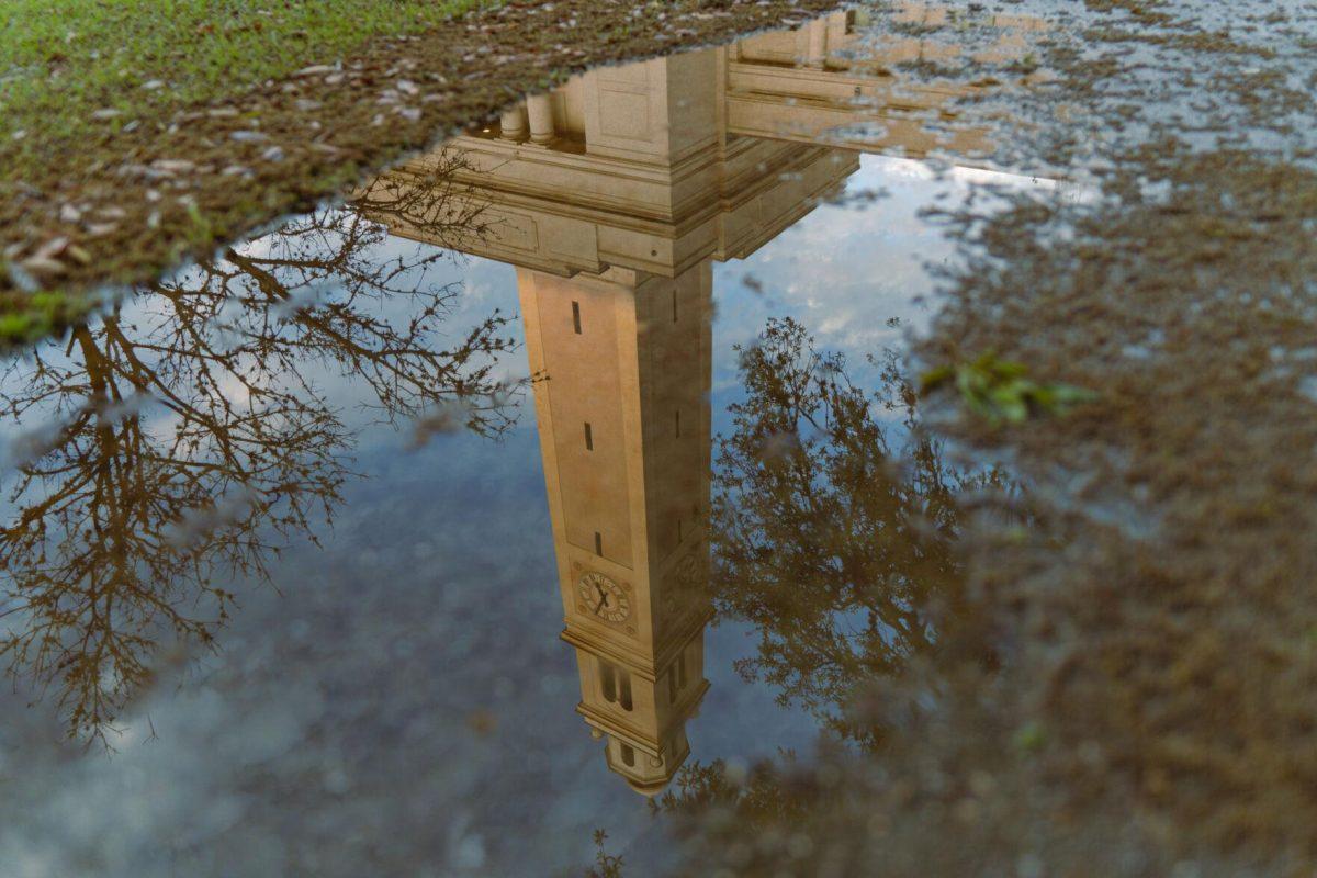 Memorial Tower reflects in a puddle on Tuesday, March 22, 2022, on Tower Drive in Baton Rouge, La.