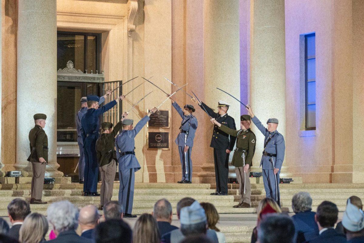 Swords make an arch into the museum on Thursday, April 7, 2022, during the LSU Memorial Tower Museum ceremony on Tower Drive in Baton Rouge, La.