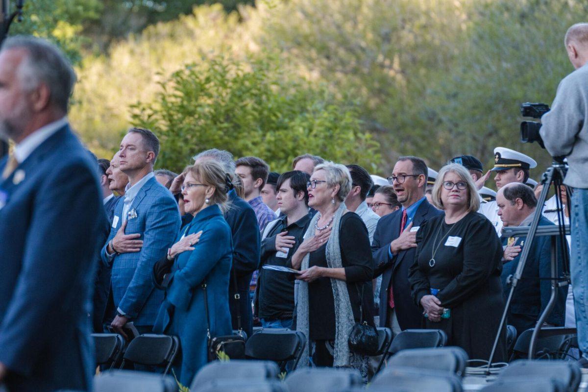 Guests stand for the national anthem on Thursday, April 7, 2022, during the LSU Memorial Tower Museum ceremony on Tower Drive in Baton Rouge, La.