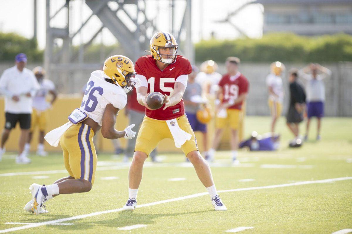 LSU football running back Tre Bradford (26) passes the ball to quarterback Myles Brennan (15) Thursday, April 21, 2022, during LSU&#8217;s spring practice in Baton Rouge, Louisiana.