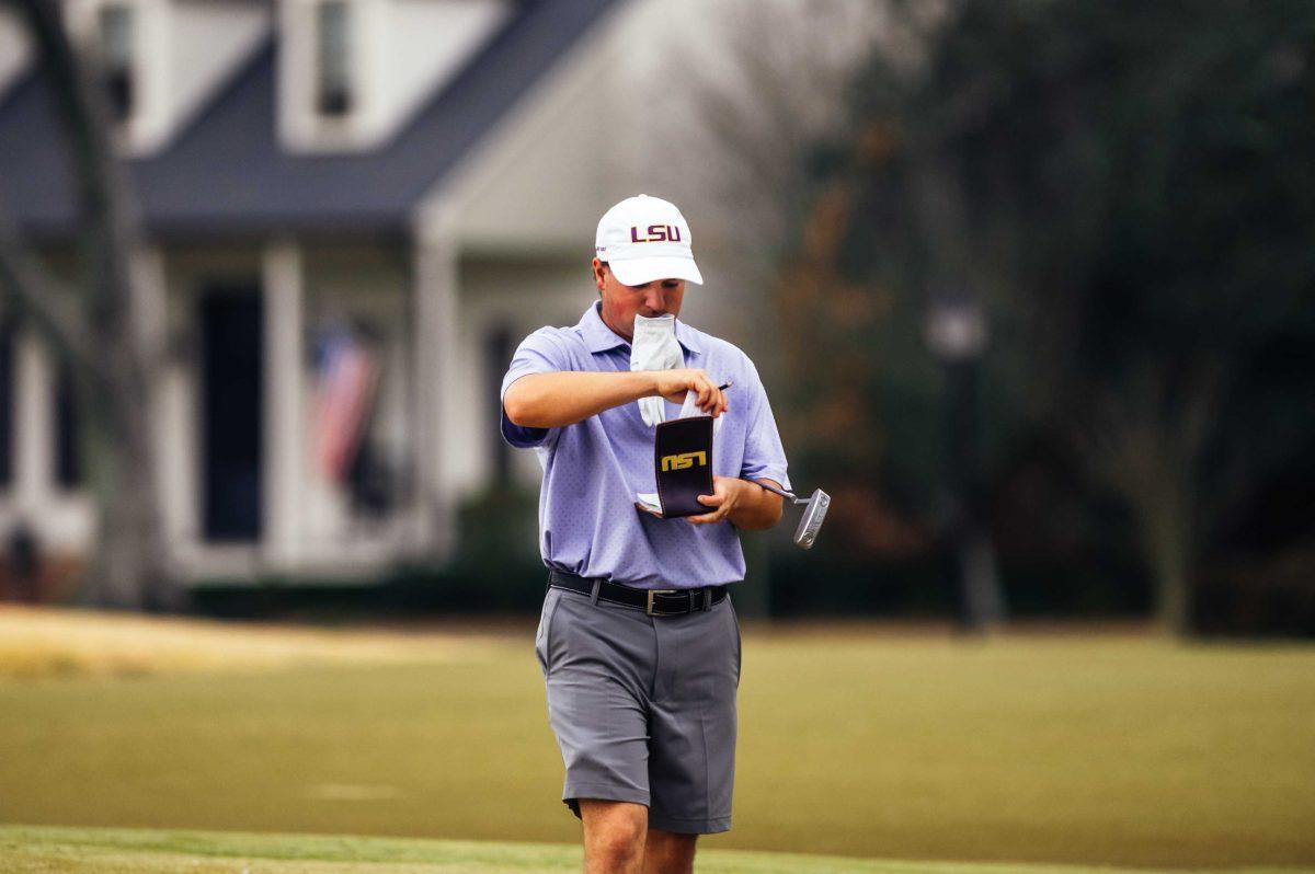 LSU men's golf freshman Nicholas Arcement looks in his score book Friday, Feb. 26, 2021 during the LSU Invitational hosted at the University Club on Memorial Tower Drive in Baton Rouge, La.