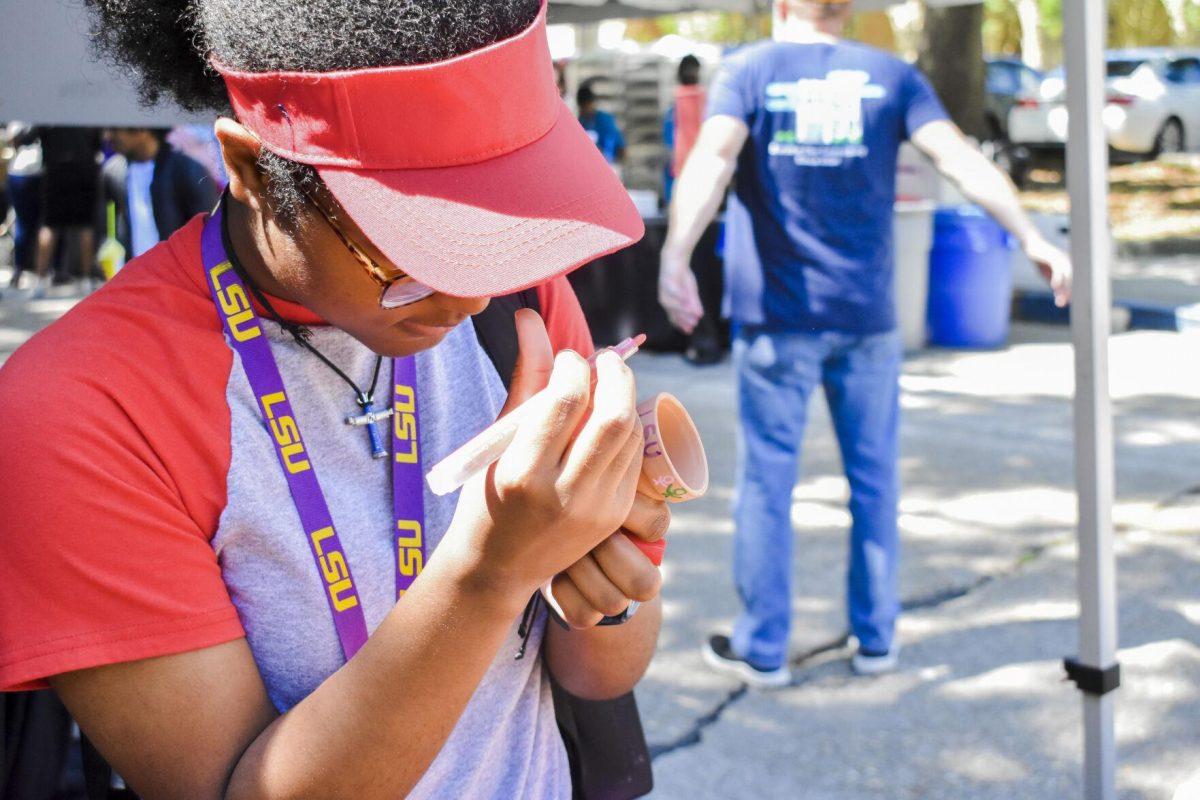 LSU biology freshman Kayla Brown decorates a tiny plant pot Wednesday, April 27, 2022, during the Grateful for Spring event on Tower Drive in Baton Rouge, Louisiana.