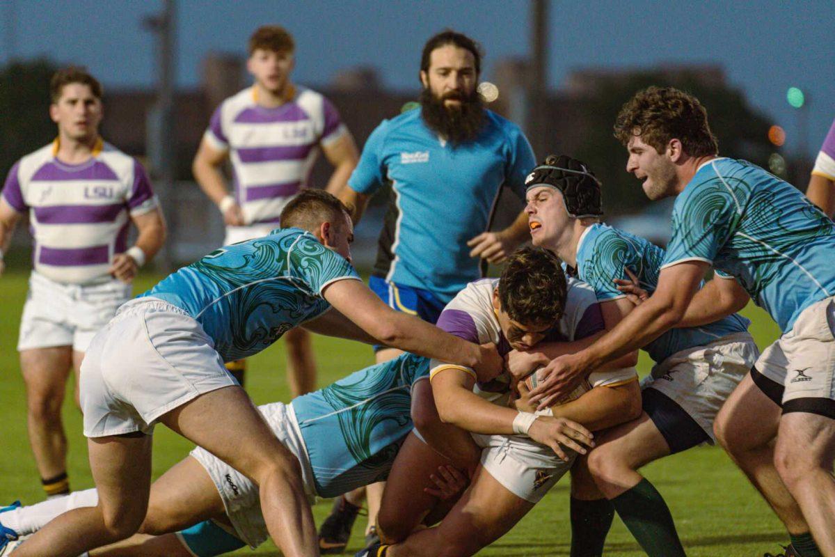 LSU Rugby prop Sam Vallejos pushes forward despite many players attempting to tackle him on Friday, April 8, 2022, during LSU&#8217;s 89-0 win over Tulane at the UREC Fields on Gourrier Avenue in Baton Rouge, La.