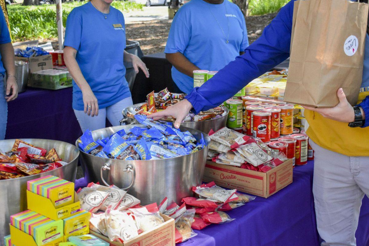 A student fills up a bag for a local food pantry Wednesday, April 27, 2022, during the Grateful for Spring event on Tower Drive in Baton Rouge, Louisiana.