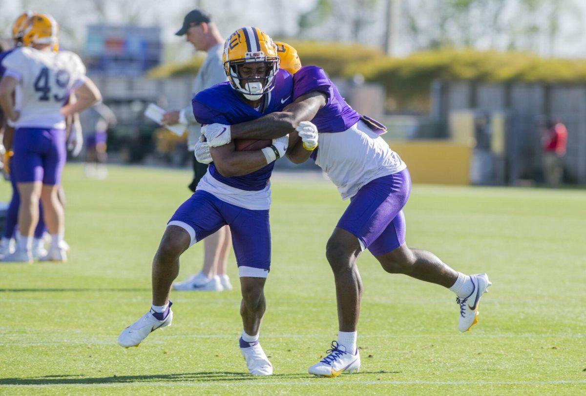 LSU football wide receiver Kyren Lacy (16) runs while being tackled Thursday, April 7, 2022, during LSU&#8217;s spring practice in Baton Rouge, Louisiana.