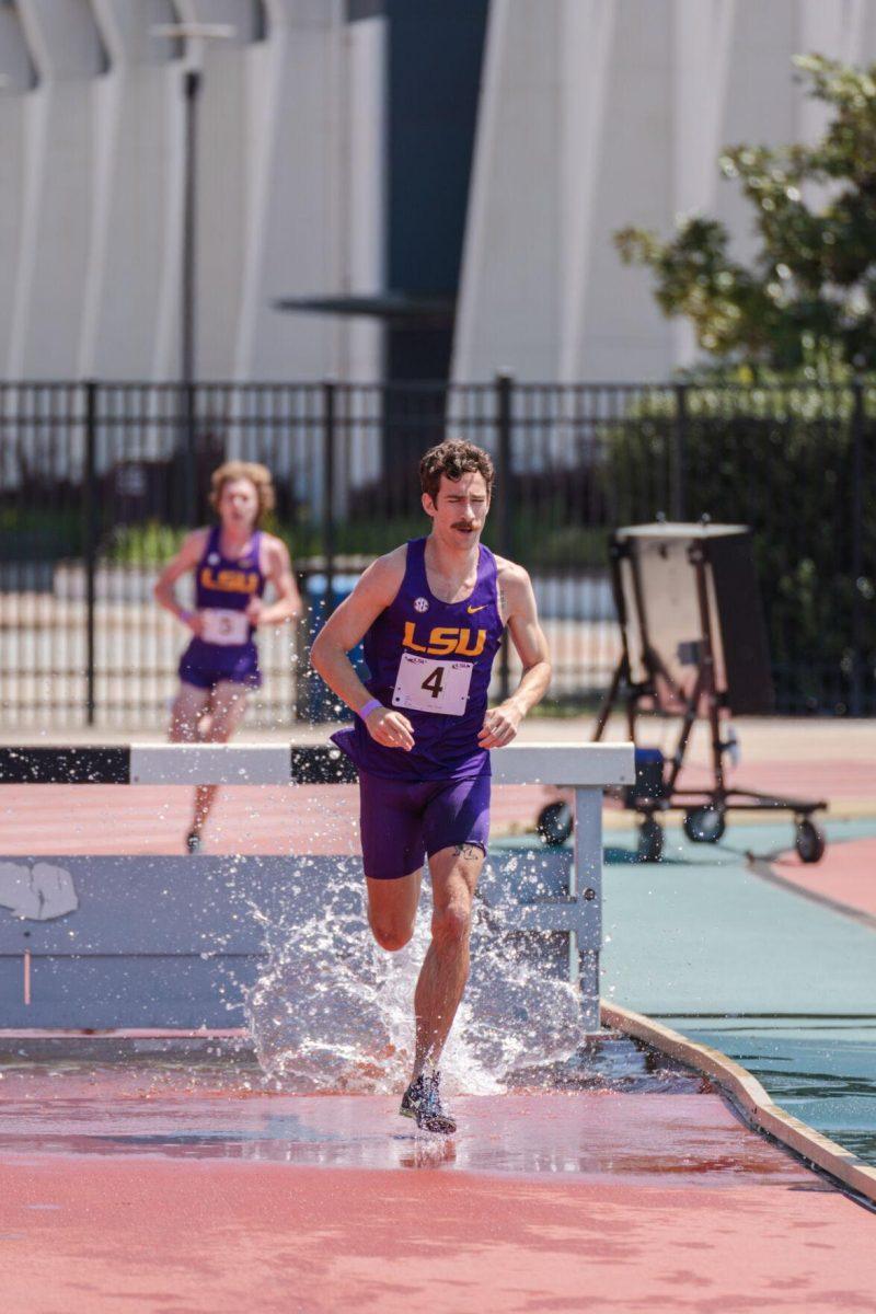 LSU track and field distance sophomore Garrett Hamilton makes a splash in the water pit on Saturday, April 2, 2022, during the 3000m steeplechase at the Battle on the Bayou track meet at Bernie Moore Stadium in Baton Rouge, La.