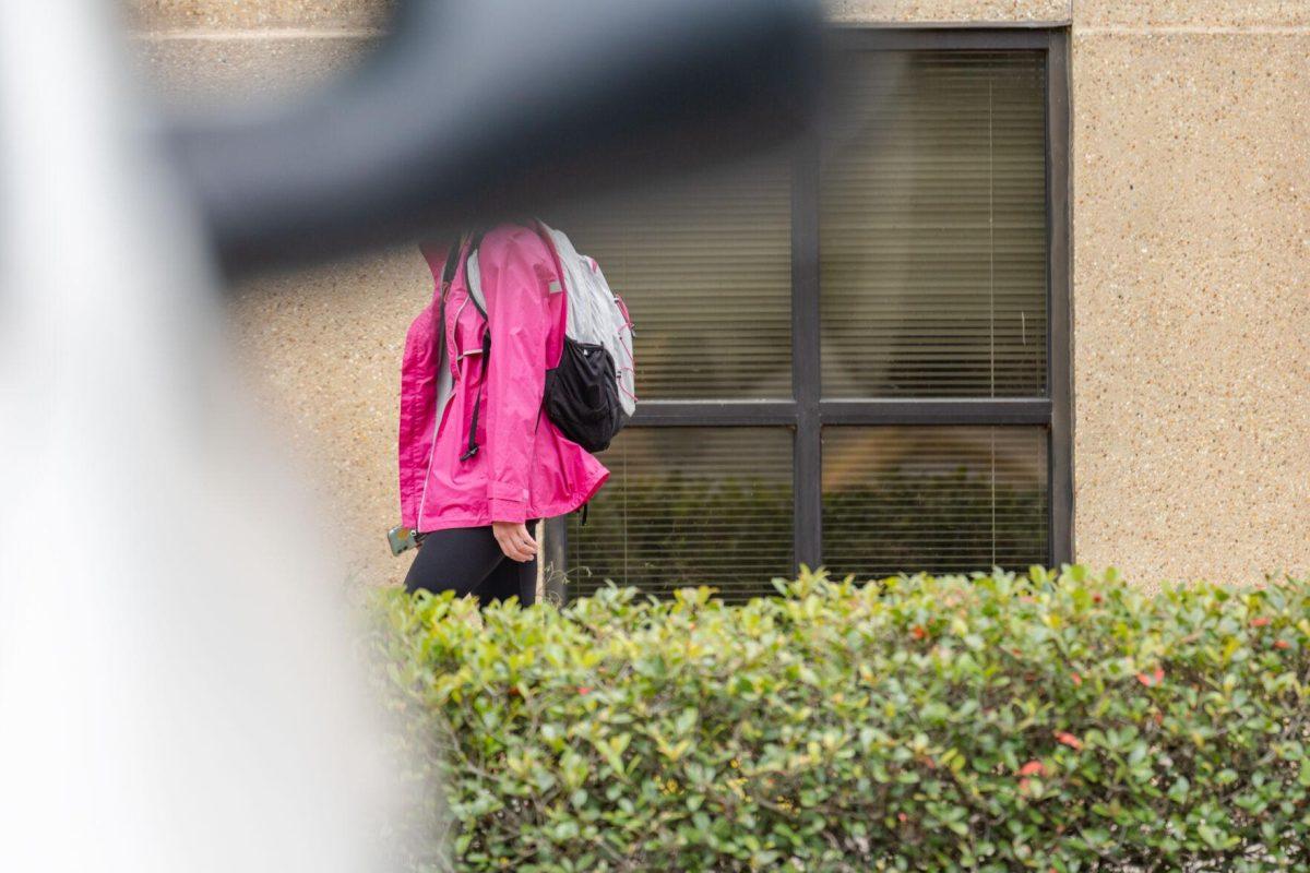 A sideview mirror obscures the head of a student on Tuesday, April 12, 2022, near Coates Hall on Tower Drive in Baton Rouge, La.