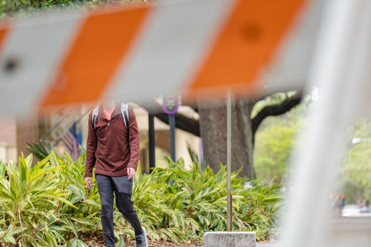 A barricade renders the walker without a head on Tuesday, April 12, 2022, near the Union Parking Garage on Veterans Drive in Baton Rouge, La.