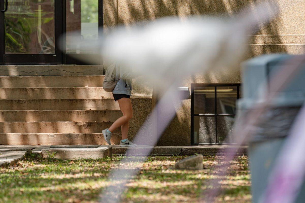 A sculpture in the art garden replaces the walker&#8217;s head for a short moment on Thursday, April 21, 2022, near the LSU Quad in Baton Rouge, La.