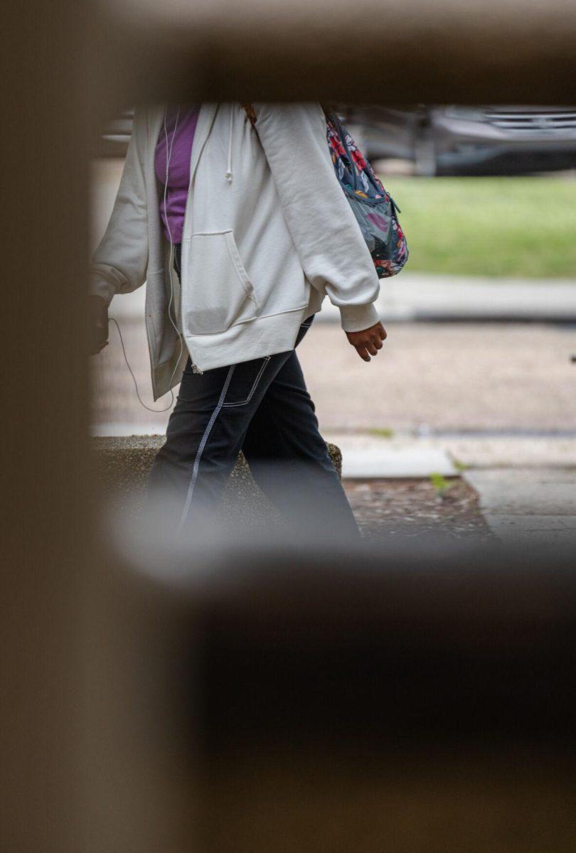 A garbage can cover removes the head of a student from view on Tuesday, April 12, 2022, on Field House Drive in Baton Rouge, La.