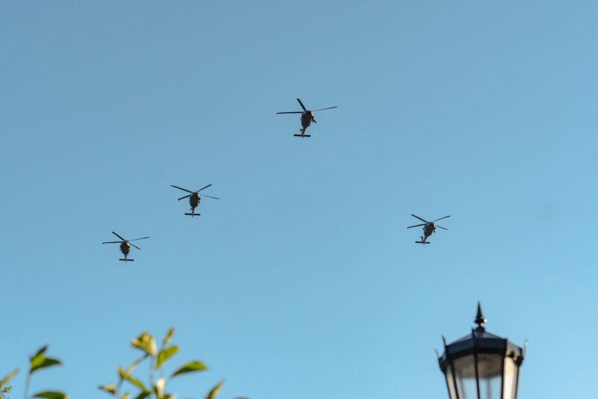 Helicopters fly overhead on Thursday, April 7, 2022, during the LSU Memorial Tower Museum ceremony on Tower Drive in Baton Rouge, La.