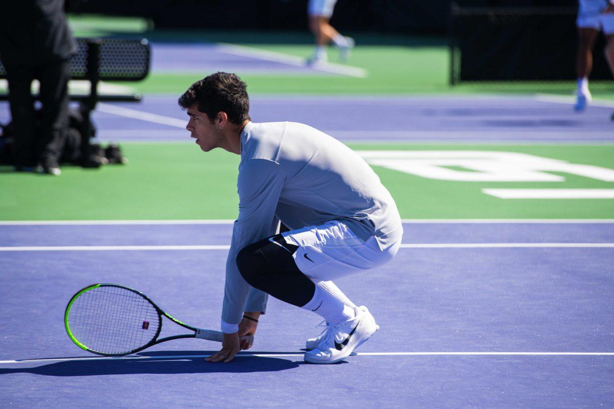 LSU men's tennis sophomore Joao Garca squats down on the court Sunday, Feb. 13, 2021 during LSU's 6-1 win over Purdue at the LSU Tennis Complex on Gourrier Avenue in Baton Rouge, La.