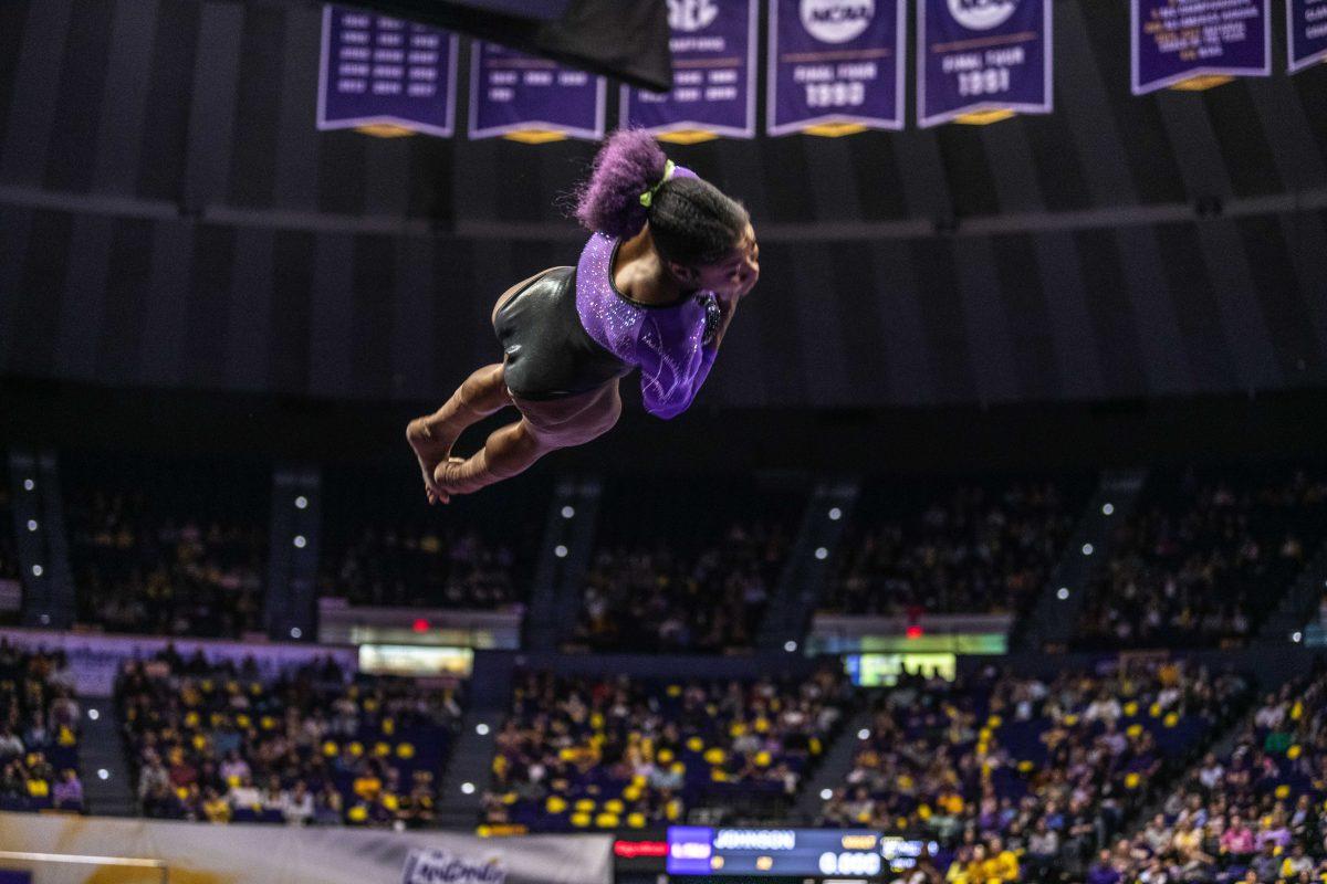 LSU gymnastics all-round junior Kiya Johnson leaps from the vault pad Friday, March 11, 2022 during LSU's 198.125-197.875 win over University of Utah in the Pete Maravich Assembly Center on N. Stadium Drive in Baton Rouge, La.