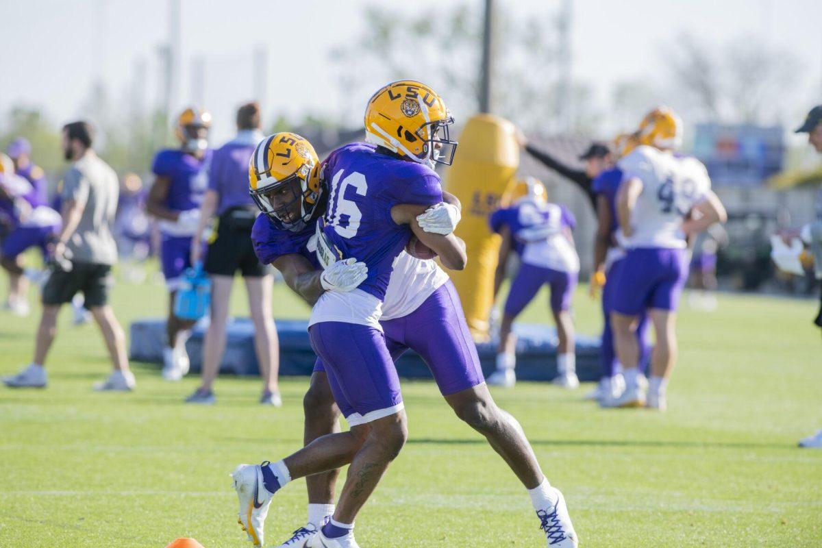 LSU football wide receiver Kyren Lacy (16) runs while being tackled Thursday, April 7, 2022, during LSU&#8217;s spring practice in Baton Rouge, Louisiana.