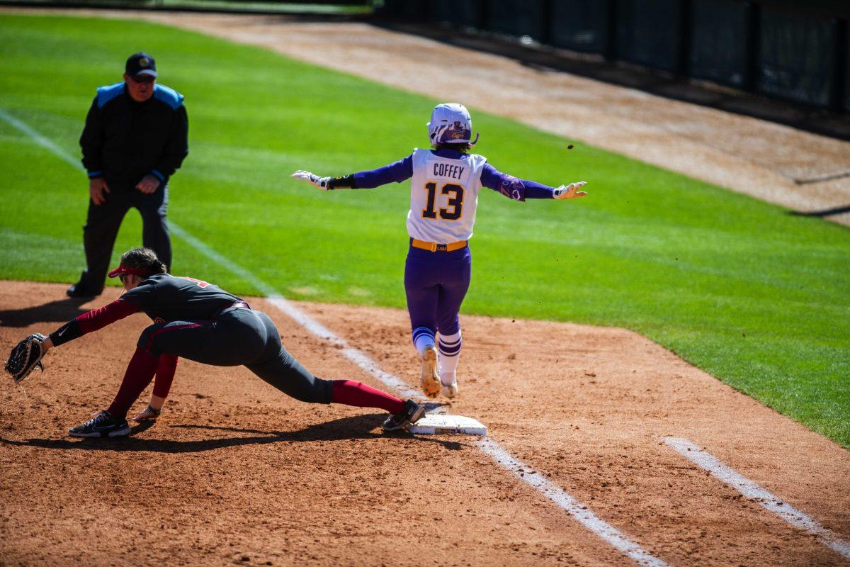 LSU softball sophomore infielder Danieca Coffey (13) signals that she is safe as she runs through first base Saturday, March 12, 2022 during LSU's 13-6 win against Alabama at Tiger Park in Baton Rouge, La.