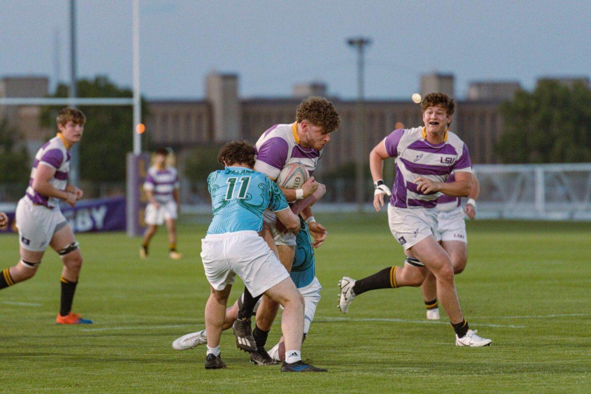 LSU Rugby number 8 Jamie Kennedy tries to break a tackle on Friday, April 8, 2022, during LSU&#8217;s 89-0 win over Tulane at the UREC Fields on Gourrier Avenue in Baton Rouge, La.