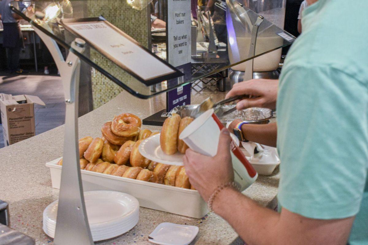 Students grab donuts from a tray Tuesday, May 3, 2022, in The 5 Dining Hall for President&#8217;s Breakfast on LSU&#8217;s campus in Baton Rouge, Louisiana.