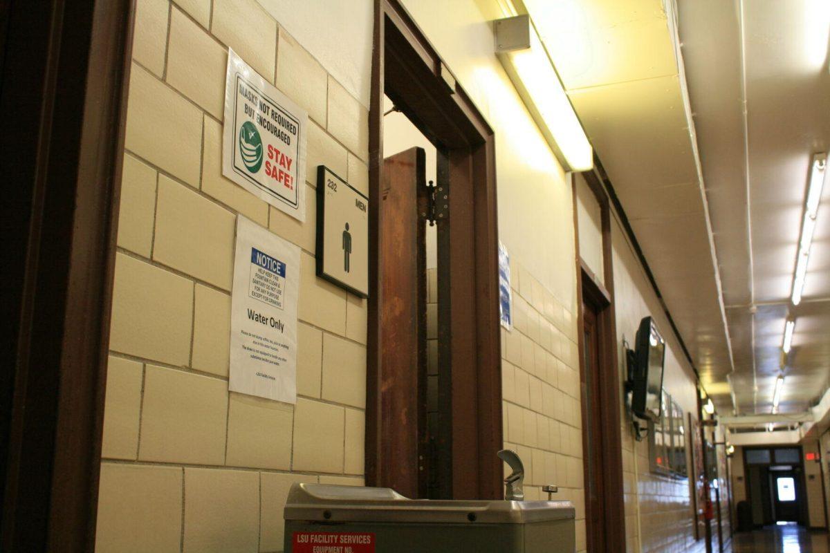 A "masks not required but encouraged" sign is posted above a water fountain on the second floor of Himes Hall on Monday, May 16, 2022.