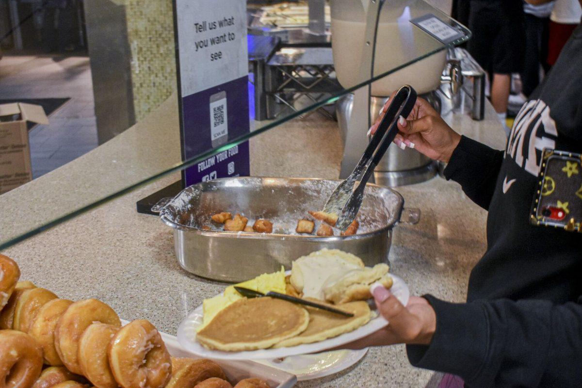 Students grab beignets from a tray Tuesday, May 3, 2022, in The 5 Dining Hall for President&#8217;s Breakfast on LSU&#8217;s campus in Baton Rouge, Louisiana.