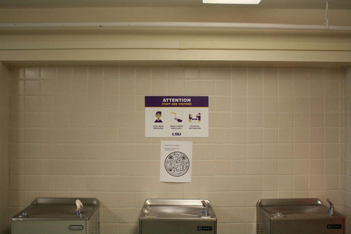 A COVID-19 warning sign is posted above water fountains in Coats Hall on Monday, May 16, 2022.