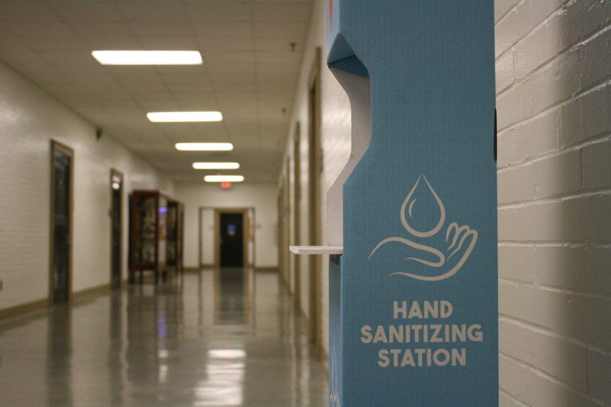 A blue "Hand Sanitizing Station" sits in Coats Hall's first floor hallway on Monday, May 16, 2022.