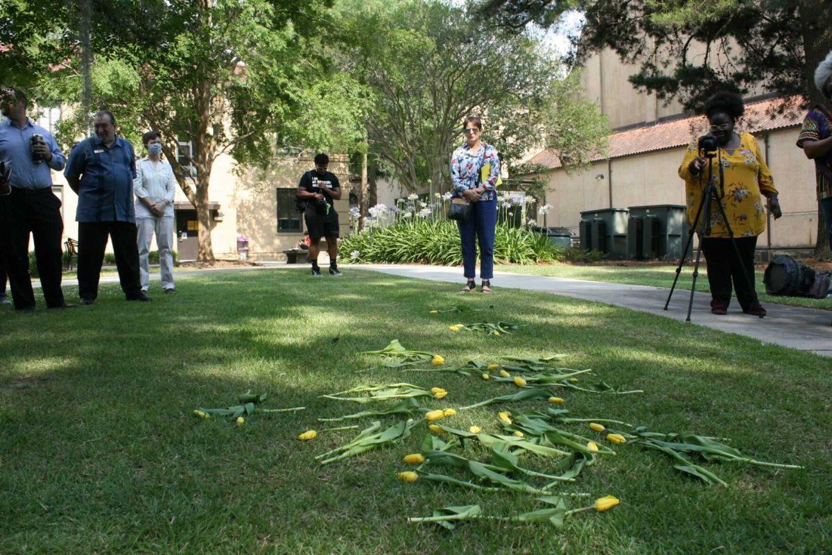 Yellow tulips placed by participants of the memorial service lie before the Student Health Center on Wednesday, May 12, 2022.