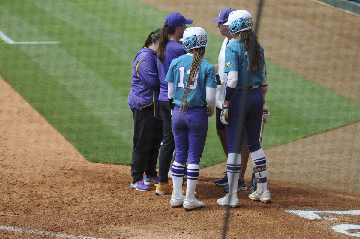 LSU redshirt junior pitcher Shelby Wickersham (11) and LSU sophomore infielder Danieca Coffey (13) meet with the cocahing staff Saturday, April 30, 2022, during LSU&#8217;s 6-1 defeat against Florida at Tiger Park on Skip Bertman Drive in Baton Rouge, La.