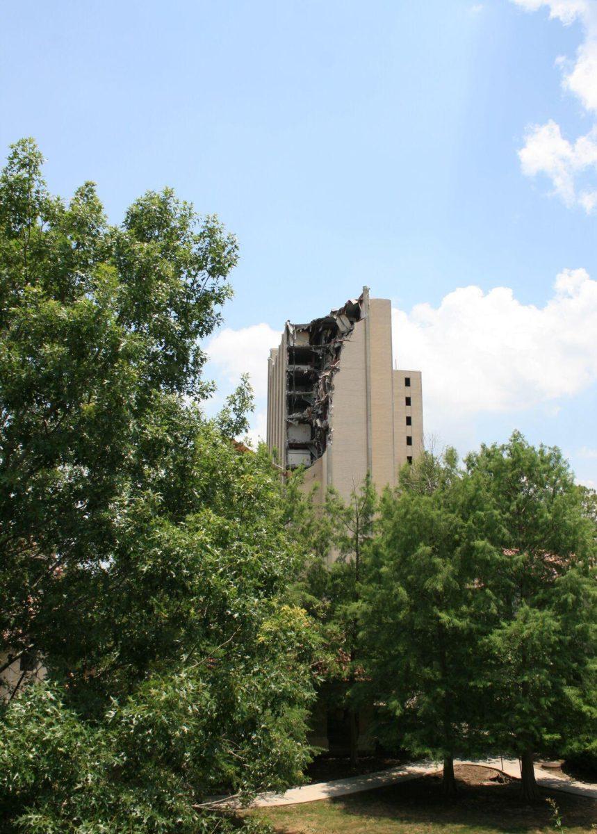 Kirby Smith towers above the trees, but not for much longer, as can be seen from West Campus Apartments. Demolition progress as of Friday, May 20, 2022.