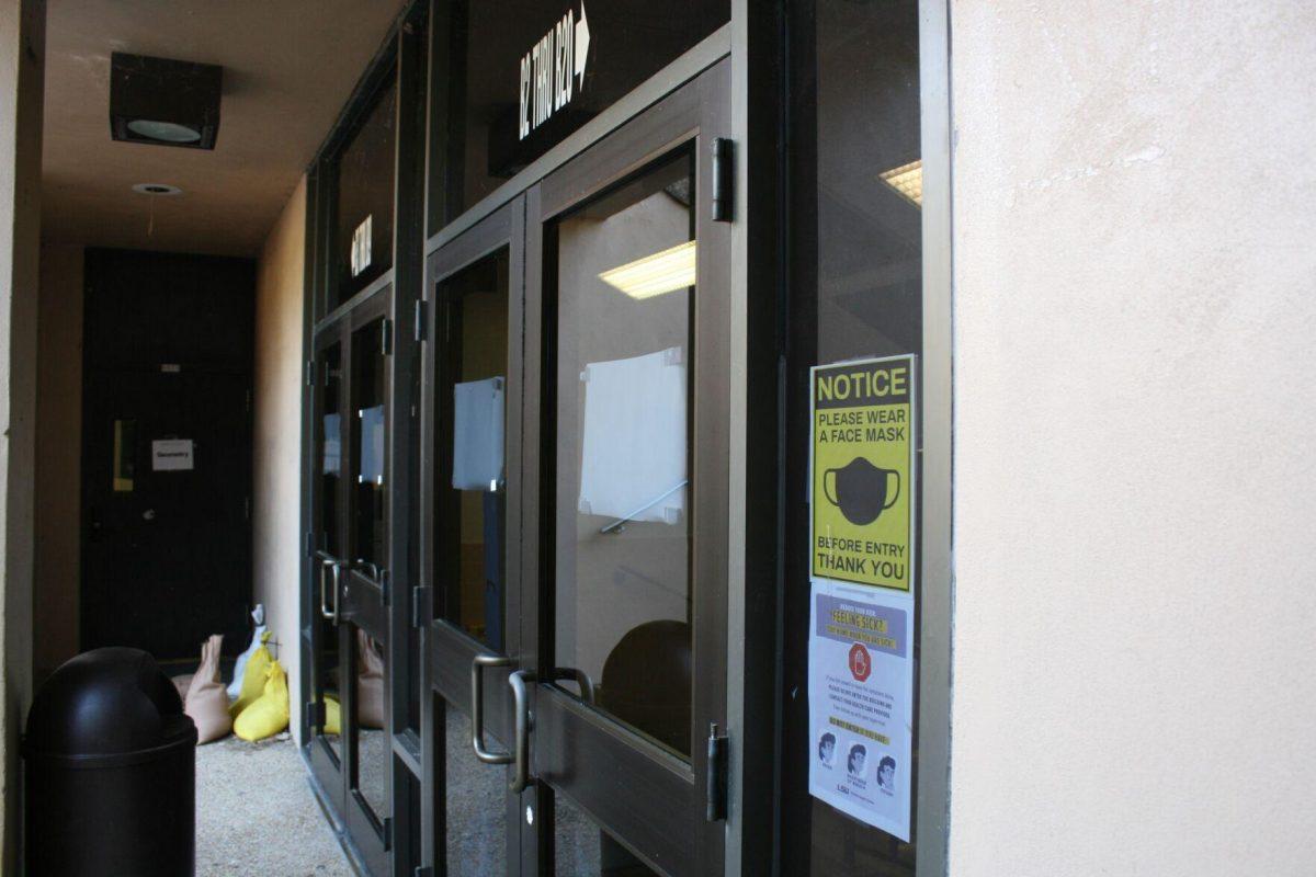 Two COVID-19 signs adorn Lockett Hall's basement entrance on Wednesday, May 18, 2022.