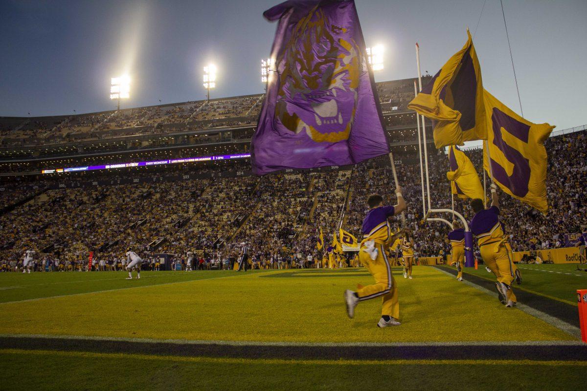 LSU cheerleaders run with flags Saturday, Sept. 18, 2021, celebrating a early touchdown at the LSU vs Central Michigan football game in Tiger Stadium.