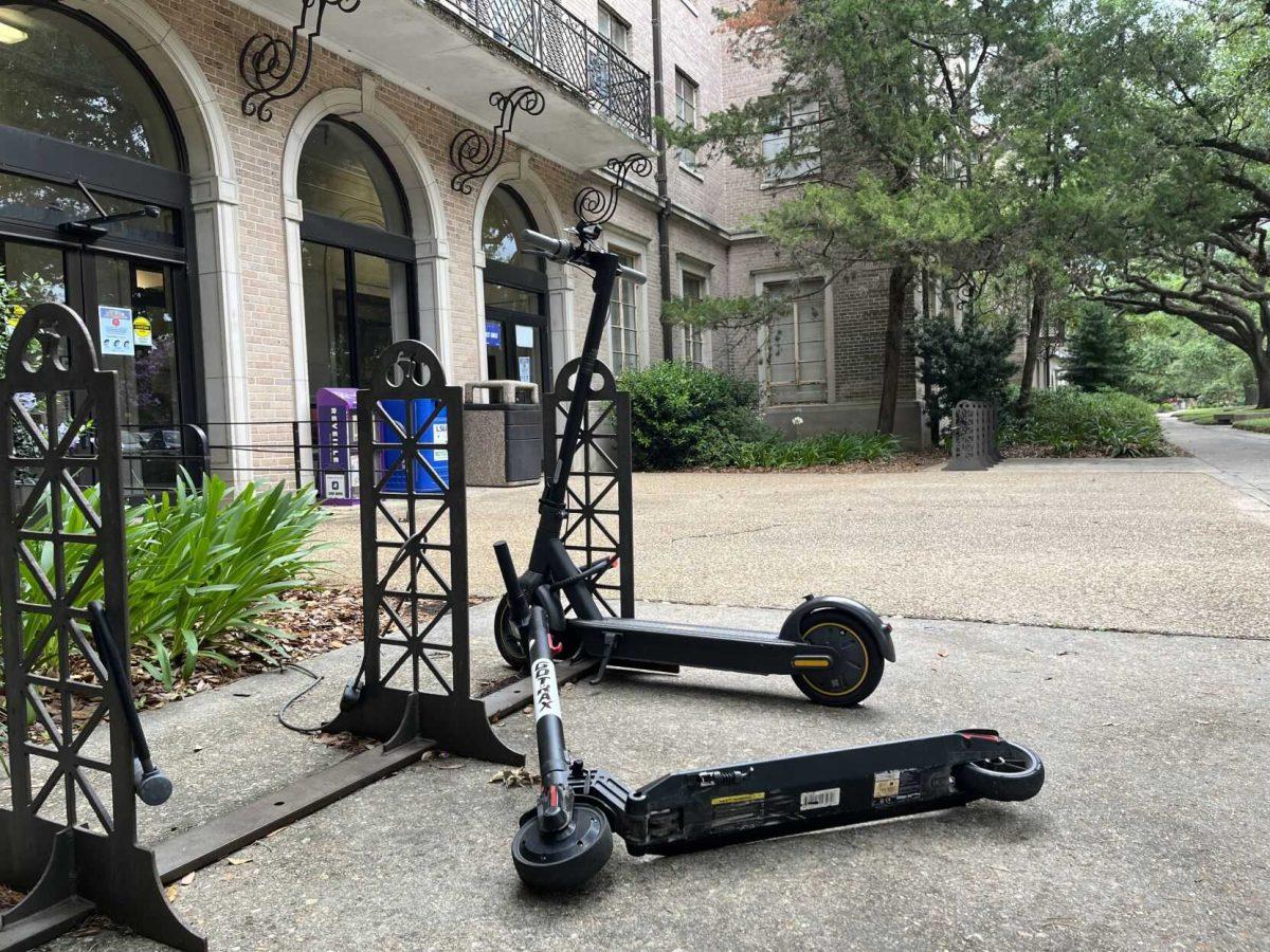 Two electric scooters sit outside of Johnston Hall.