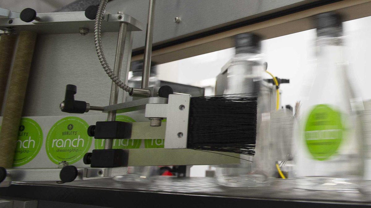 Bottles are labeled during a test run of the LSU AgCenter Food Incubator&#8217;s new bottling line, Feb. 4, 2020. / Courtesy of Olivia McClure