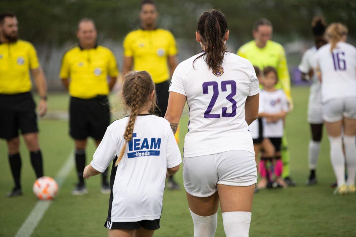 LSU soccer freshman midfielder Raelyn Prince (23) holds a young fans’ hand Thursday, Aug. 18, 2022, before LSU's 5-0 win against Stephen F. Austin at LSU's Soccer Stadium off of Nicholson Drive.
