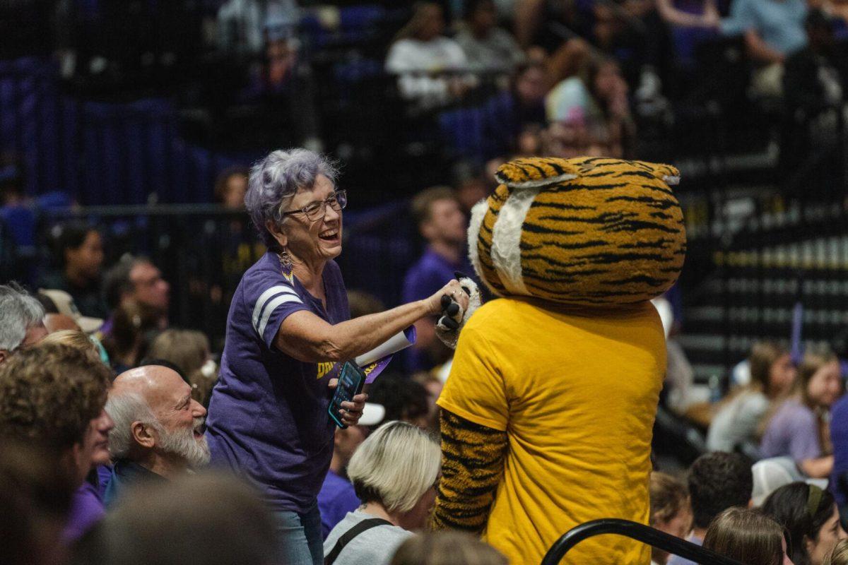 A fan meets Mike the Tiger in the stands on Friday, Aug. 26, 2022, during LSU&#8217;s 3-1 loss against Houston in the Pete Maravich Assembly Center in Baton Rouge, La.