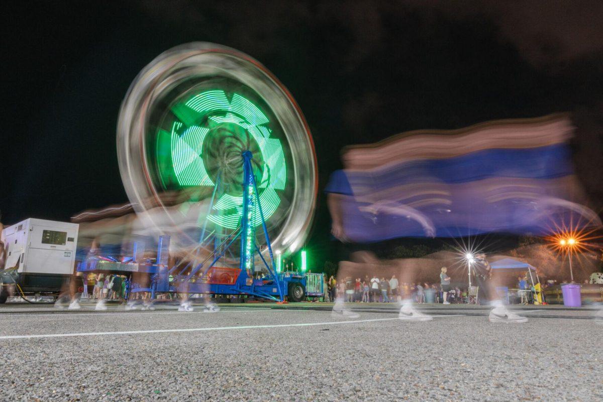 Freshmen walk past the Ferris Wheel on Saturday, Aug. 20, 2022, at the Welcome Week Carnival near Tiger Stadium on South Stadium Drive in Baton Rouge, La.