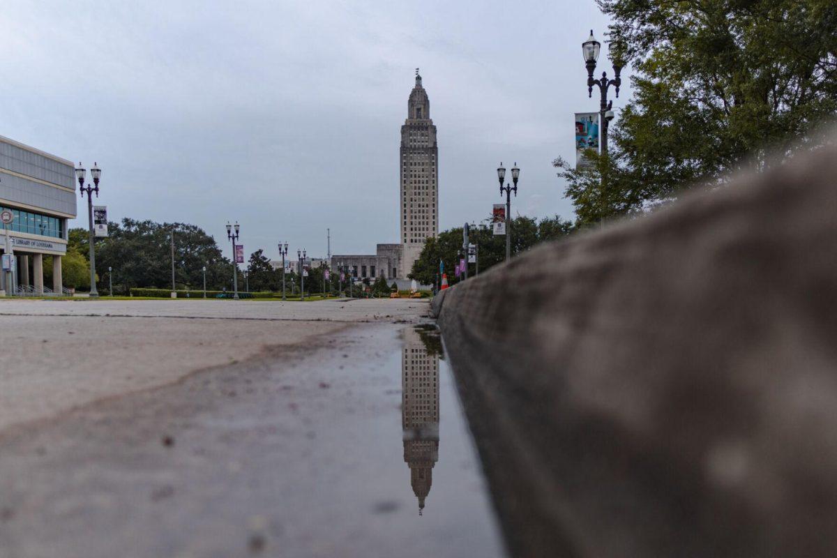 The Louisiana State Capitol reflects in a puddle on Monday, Aug. 22, 2022, on North 3rd Street in Baton Rouge, La.