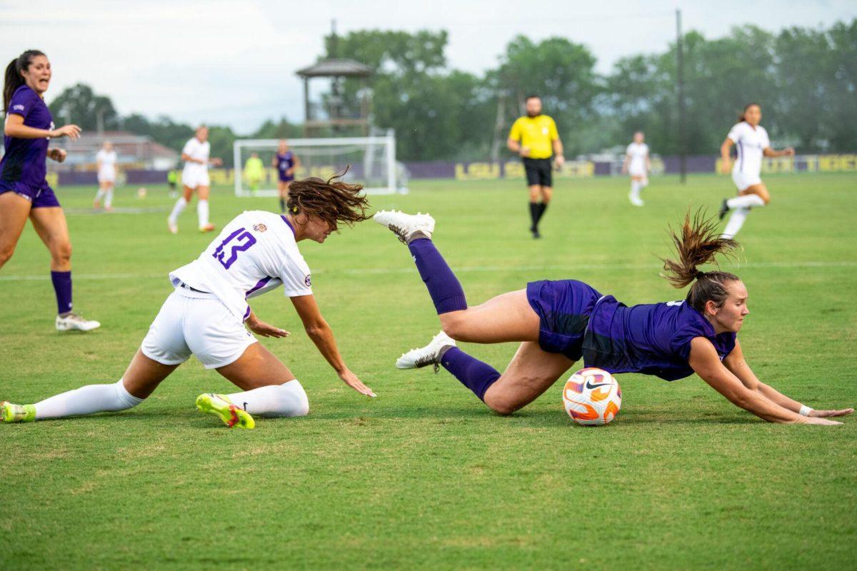 LSU soccer redshirt junior forward Taylor Dobles (13) and Stephen F. Austin women’s soccer fifth-year defender Paige Kanipes (3) fall to the ground after fighting for the ball Thursday, Aug. 18, 2022, during LSU’s 5-0 win against Stephen F. Austin at LSU's Soccer Stadium off of Nicholson Drive.