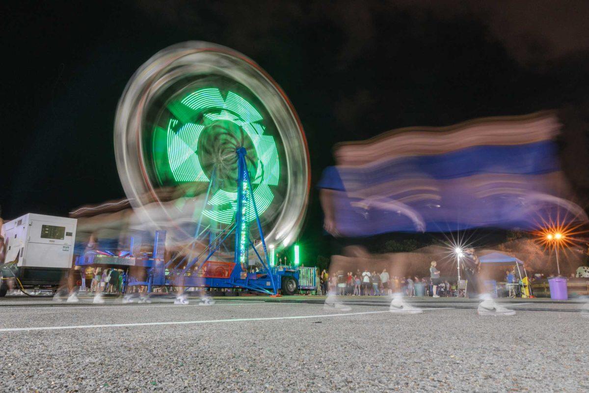 Freshmen walk past the Ferris Wheel on Saturday, Aug. 20, 2022, at the Welcome Week Carnival near Tiger Stadium on South Stadium Drive in Baton Rouge, La.