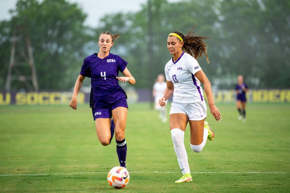 LSU soccer redshirt junior forward Taylor Dobles (13) and Stephen F. Austin women’s soccer fifth-year defender Mattie Musser (4) race after the ball Thursday, Aug. 18, 2022, during LSU’s 5-0 win against Stephen F. Austin at LSU's Soccer Stadium off of Nicholson Drive.