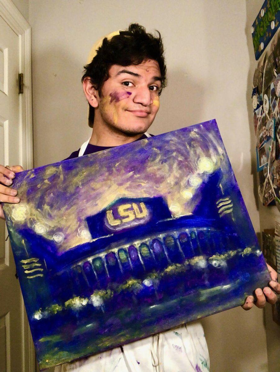 Nico Budde poses with a painting of LSU's Tiger Stadium.