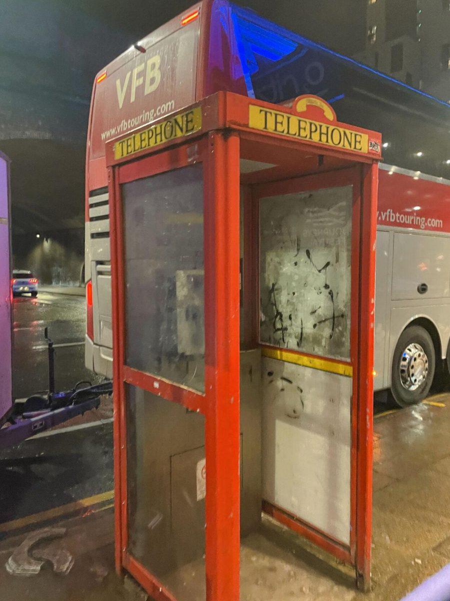 A telephone booth sits in the street light on a rainy night in Manchester, U.K.